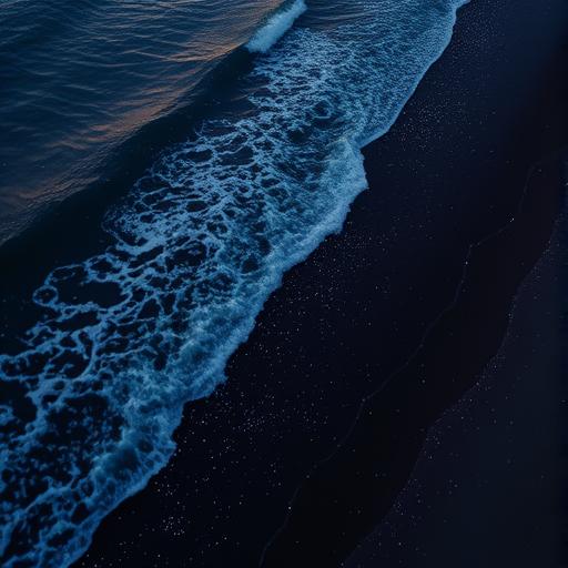 An aerial view of a beach at dusk with waves lapping